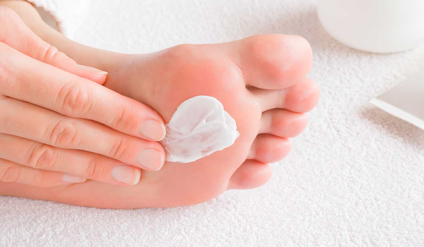 Aplicação de creme hidratante nos pés